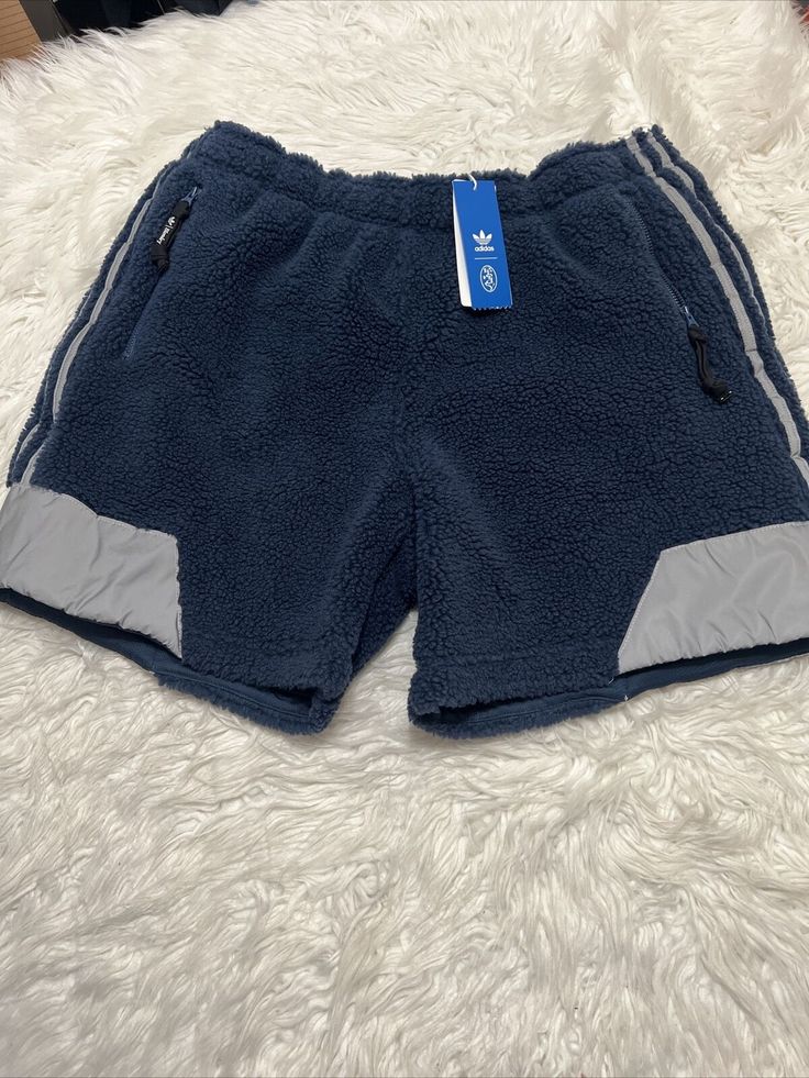 Upgrade your activewear collection with these Adidas Brandey Sherpa athletic sweat shorts in size XL, featuring a classic blue color and drawstring closure for a comfortable fit. These shorts are made of 73% polyester with a Sherpa fabric type, making them warm, soft, and moisture-wicking. Perfect for a variety of performance activities such as gym and training, track and field, soccer, basketball, and more, these shorts also have an 8-inch inseam and are lined for added comfort. Don't miss out on these high-quality shorts by Adidas, a trusted brand in sportswear. Adidas Sporty Bottoms With Built-in Shorts, Adidas Relaxed Fit Moisture-wicking Bottoms, Adidas Nylon Activewear, Adidas Athleisure Nylon Activewear, Adidas Activewear Sportswear, Adidas Cotton Sportswear Shorts, Sportswear Shorts With Functional Drawstring For Outdoor, Casual Adidas Sports Bottoms, Adidas Casual Sports Bottoms