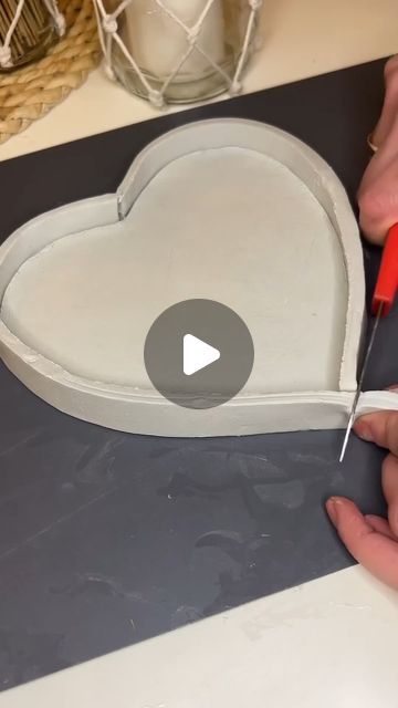 someone is making a heart shaped cake with icing