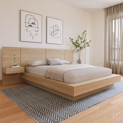 a large bed sitting on top of a wooden floor next to a wall mounted art