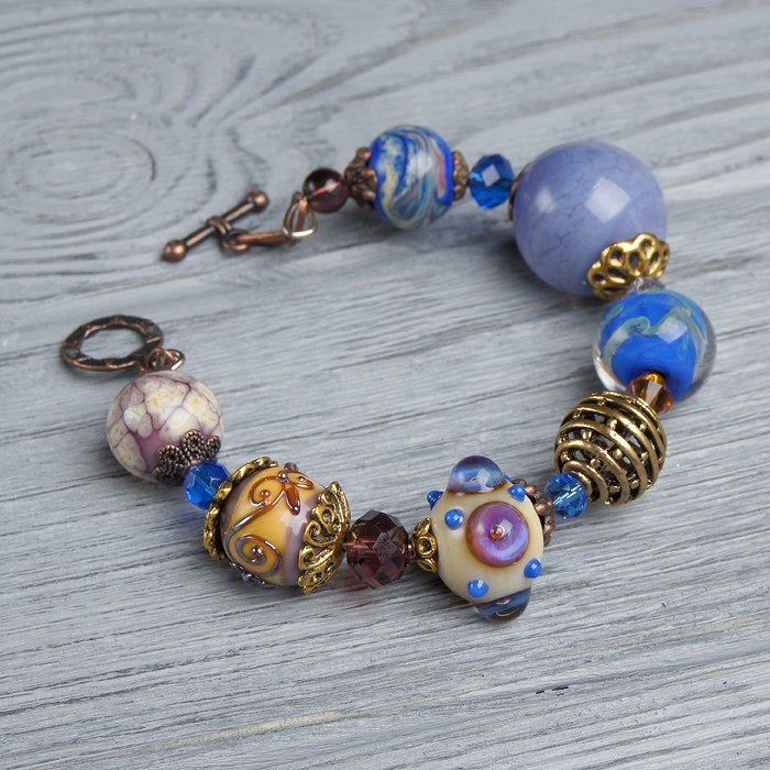 "This Lavender boho bracelet bracelet is a perfect gift for women. It's very tender and unique! This lampwork bracelet fits a 15.5-16.5cm (6.1\"-6.5\" inch) diameter wrist. If you need bigger or smaller size bracelet, please, write me the diameter of your wrist when making an order. Dimentions: 21cm. Materials: artist lampwork beads, metal and glass beads, metal fittings. Colors used: blue, lavender, lilac. Please, note, each lampwork bead is made by hand and may differ slightly. All the photos Adjustable Bohemian Crystal Bracelet With Large Beads, Adjustable Bohemian Czech Glass Beaded Bracelets, Bohemian Bracelets With Spacer Beads For Gift, Bohemian Bracelets With Spacer Beads As Gift, Bohemian Beaded Bracelets With Faceted Beads For Jewelry Making, Bohemian Crystal Bracelet With Large Beads For Gift, Bohemian Czech Glass Bracelets With Large Beads, Bohemian Bracelet With Faceted Beads, Artisan Beaded Glass Bracelets