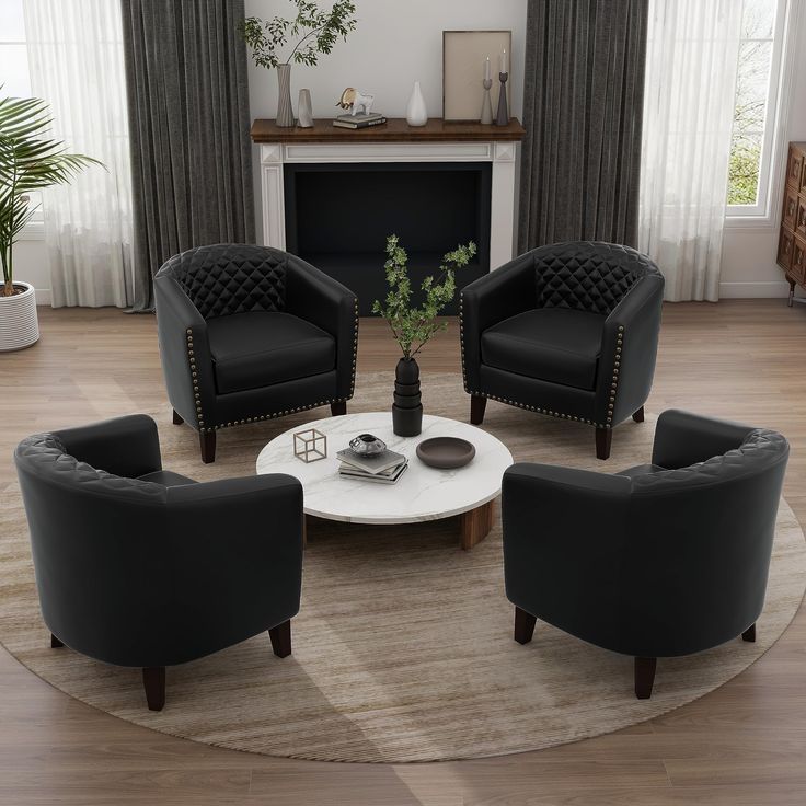 a living room with black chairs and a white coffee table in front of a fireplace