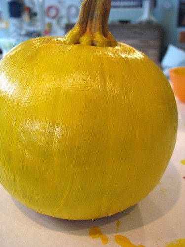 a yellow painted pumpkin sitting on top of a table