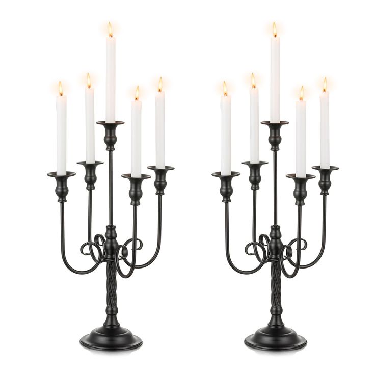 a couple of black candelabras sitting next to each other on a white background