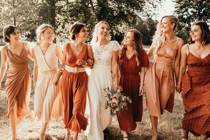 a group of women standing next to each other on top of a grass covered field