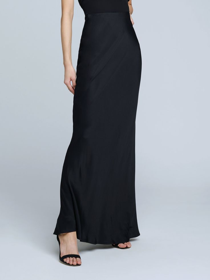 A stunning, understated maxi skirt in pure black. Bias-cut, silk-like fabric falls in a subtle, lustrous cling over the figure, enhancing and elongating the silhouette. Smooth elastic waist with no closures. Floor-length Satin Skirt For Gala, Elegant Bias Cut Skirt For Party, Elegant Satin Maxi Skirt With Bias Cut, Elegant Flowy Bias Cut Skirt, Elegant Satin Bias Cut Maxi Skirt, Elegant Bias Cut Maxi Skirt, Elegant Bias Cut Flowy Skirt, Formal Flowy Bias-cut Skirt, Sleek Fitted Bias Cut Skirt