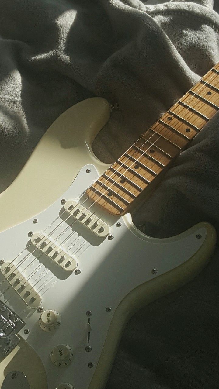 an electric guitar laying on top of a bed