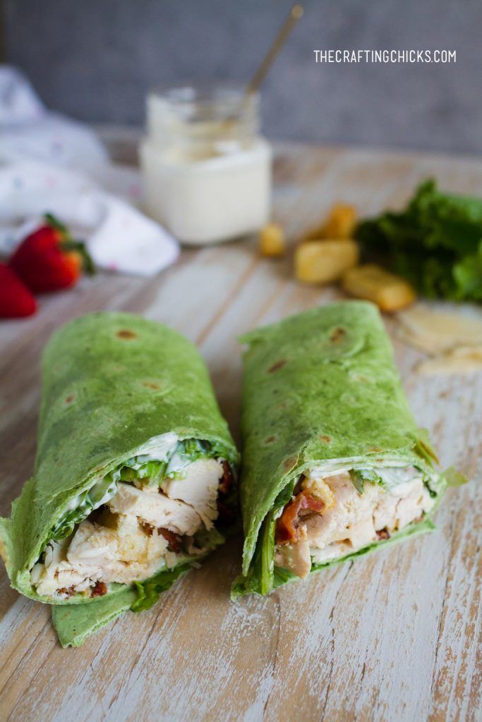 two wraps filled with chicken and vegetables on a cutting board