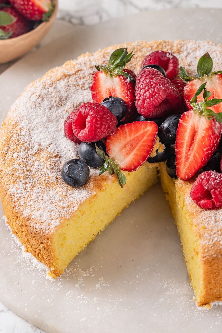 a cake with berries and powdered sugar on top