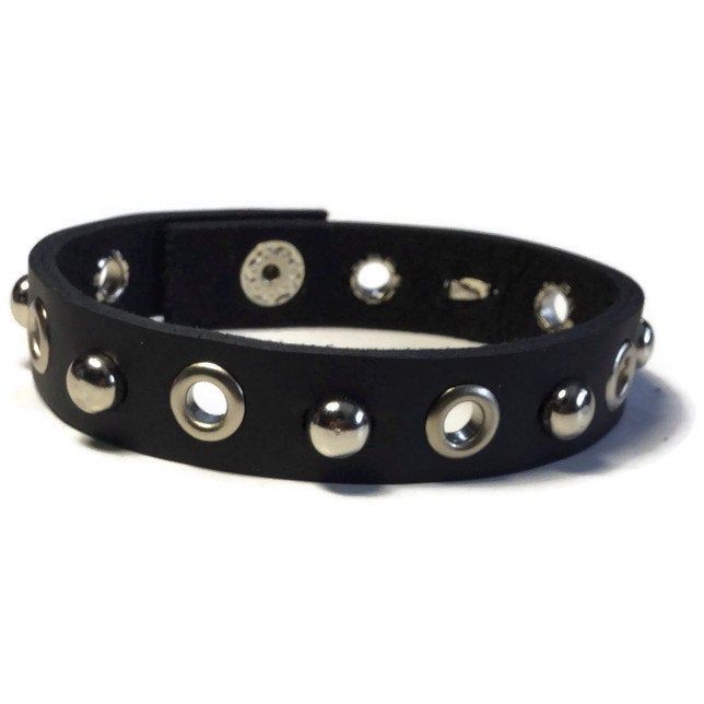 "Studded Leather Bracelet - Silver Grommet Studded Matte Black Leather Wristband - 1/2 Inch Black Leather Wristband This black leather wristband is 1/2 wide and about 8 inches long. It can fit a wrist 7.5\" around. The strap is made of handcut cowhide Genuine leather. It have added 6 Grommet Studs evenly spaced across the center and alternated with 6mm silver dome studs. I have added a silver snap button closure on the ends. It's a strong snap...it does not unsnap easily so there is no fear of i Black Band Wristband For Concerts, Adjustable Punk Style Bracelets As Fashion Accessory, Adjustable Band Bracelet As Fashion Accessory, Punk Style Adjustable Leather Bracelet With Black Band, Adjustable Black Leather Punk Bracelet, Punk Style Adjustable Leather Bracelet, Adjustable Wrist Strap Wristlet For Party, Edgy Silver Bracelets With Black Band, Edgy Silver Bracelet With Black Band