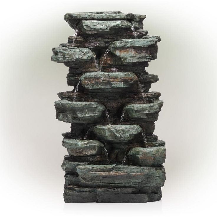 a water fountain made out of green rocks