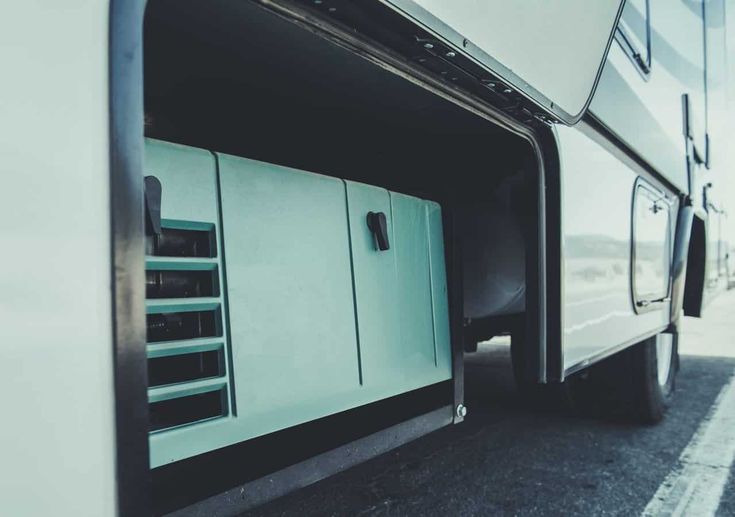 an rv parked on the side of the road with its door open to let people inside