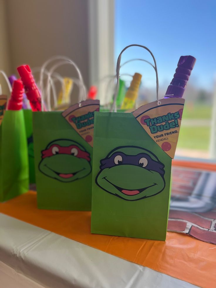 two teenage mutant bags sitting on top of a table with pens and markers in them