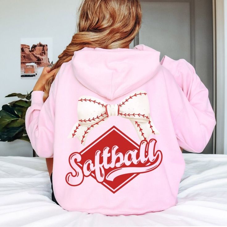 Hit a Home Run with Our "Softball" Coquette Bow Hoodie Sweatshirt!  Searching for the perfect Softball Sweatshirt or Softball Hoodie? Look no further! Our "Softball" Coquette Bow Hoodie Sweatshirt is a game-changer for any softball fan. Whether you're looking for Cute Softball Hoodies for Girls, Softball Mom Sweatshirts, or a unique gift for your softball team, this hoodie is designed to impress and keep you cozy all season long. Why You'll Love Our "Softball" Coquette Bow Hoodie Sweatshirt: Unm Softball Hoodies, Bow Hoodie, Softball Team Shirt, Softball Sweatshirt, Softball Team Gifts, Hoodies For Girls, Softball Outfits, Sweatshirt Oversized, Girls Softball