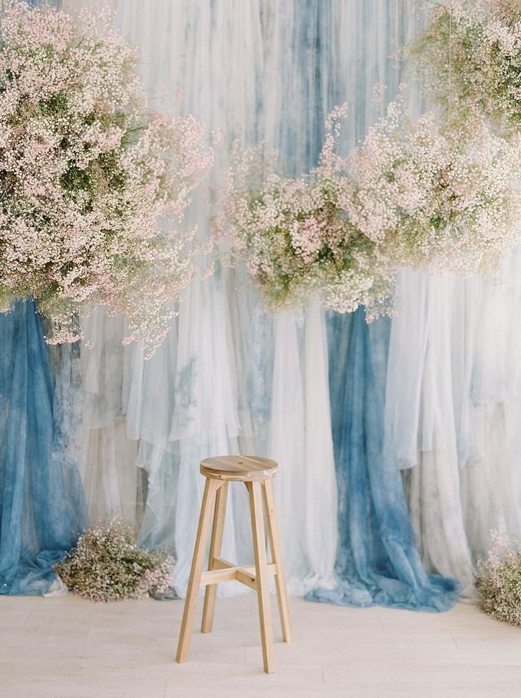 a stool in front of a backdrop with flowers