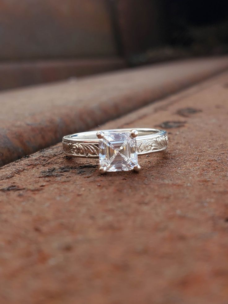 a white diamond ring sitting on top of a brick wall