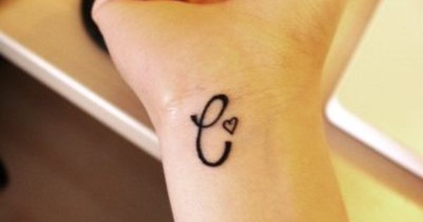 a woman's wrist tattoo with the letter e on it