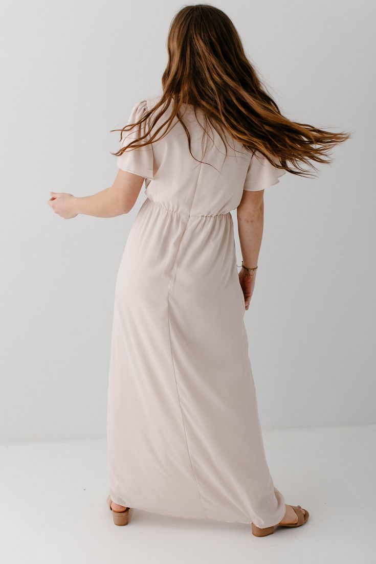 The modest formal maxi dress that you have been waiting for! The ‘Naomi’ is effortless and feminine - the perfect pick for family photos, an elegant party, or a modest bridesmaid dress. This timeless dress features a modest scoop neckline, flutter sleeves, and a chiffon overlay. The lightly gathered elastic waist and zipper closure allow for ease of styling and a flattering fit. This dress is fully lined - no layering required! Exclusively designed with you in mind. Self & Lining 100% Polyester Feminine Formal Maxi Dress, Modest Chiffon Maxi Dress, Fitted Solid Color Maxi Dress For Wedding Guests, Modest Flowy Floor-length Maxi Dress, Flowy Modest Floor-length Maxi Dress, Modest Floor-length Maxi Dress For Evening, Modest Long Chiffon Dress, Feminine Maxi Dress For Prom, Elegant Chiffon Bridesmaid Maxi Dress