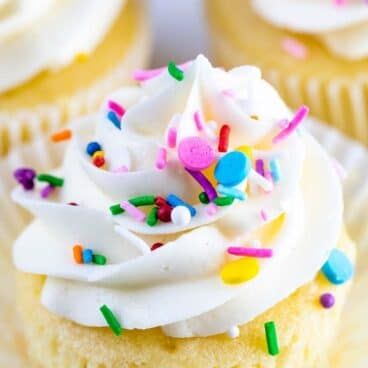 a cupcake with white frosting and sprinkles on it's top