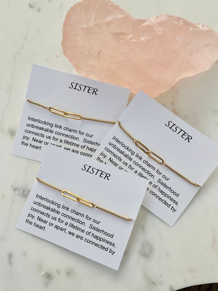 three sister bracelets on top of a table next to a pink quartz crystal rock