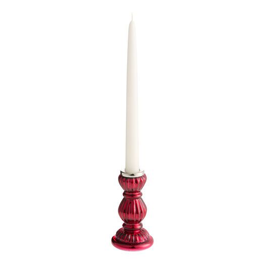 a red candle holder with a white candle in it's center on a white background