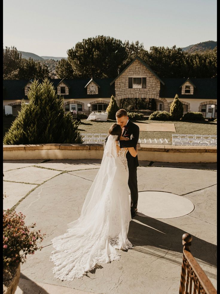 a bride and groom standing in front of their home