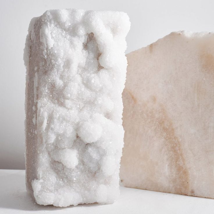 a piece of white soap sitting on top of a counter next to a block of foam