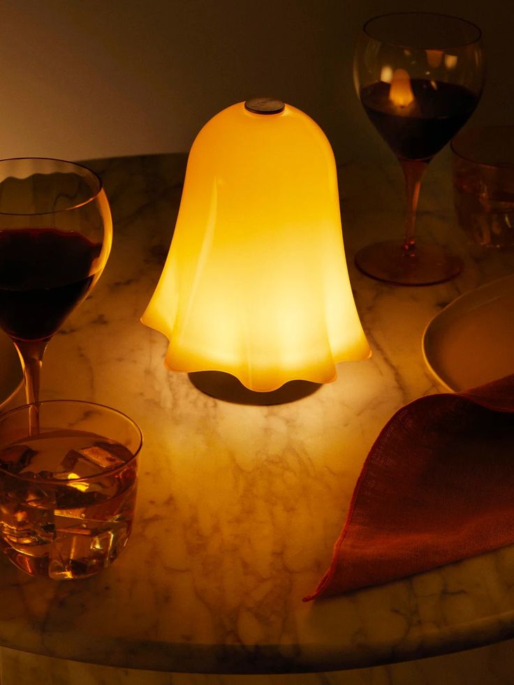 a table topped with wine glasses next to a light on top of a marble counter