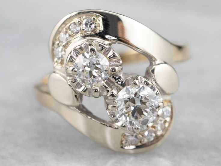 a diamond ring with three stones in it on a white surface and one stone has been cut into the shape of a flower