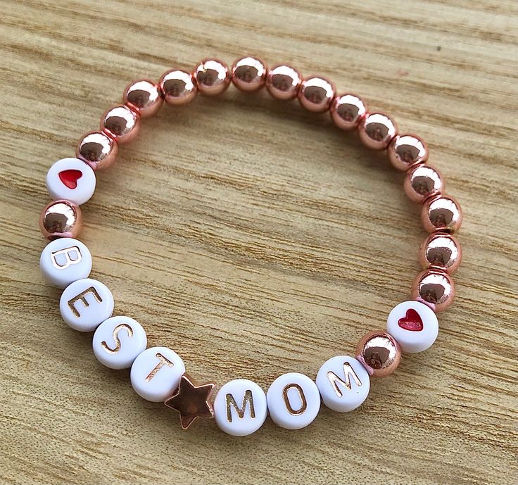 Hello and welcome. Mother's Day bracelets. You can build your own from Bead sample picture or choose one of my displays. I offer wooden beads, silver, gold, rose gold, dark gold and brownish gold beads. Also light pink pearl beads. As accents I offer heart shape beads in silver and rose gold. Start is gold, rose and silver. Round heart beads in red, blue, pink and black. Letter choice is white/black or white/rose gold. Each bracelet is stretchy and will come in an organza bag ready for gift givi Mother Day Bracelet Ideas, Mom Bead Bracelets, Mothers Day Bracelet Ideas, Personalized Name Bracelet For Best Friend, Mother's Day Gift, Personalized Name Bracelet For Best Friend And Mother's Day, Personalized Name Bracelet For Best Friend On Mother's Day, Mother’s Day Bracelet Ideas, Handmade Rose Gold Bracelets For Mother's Day, Rose Gold Custom Name Bracelet For Gift