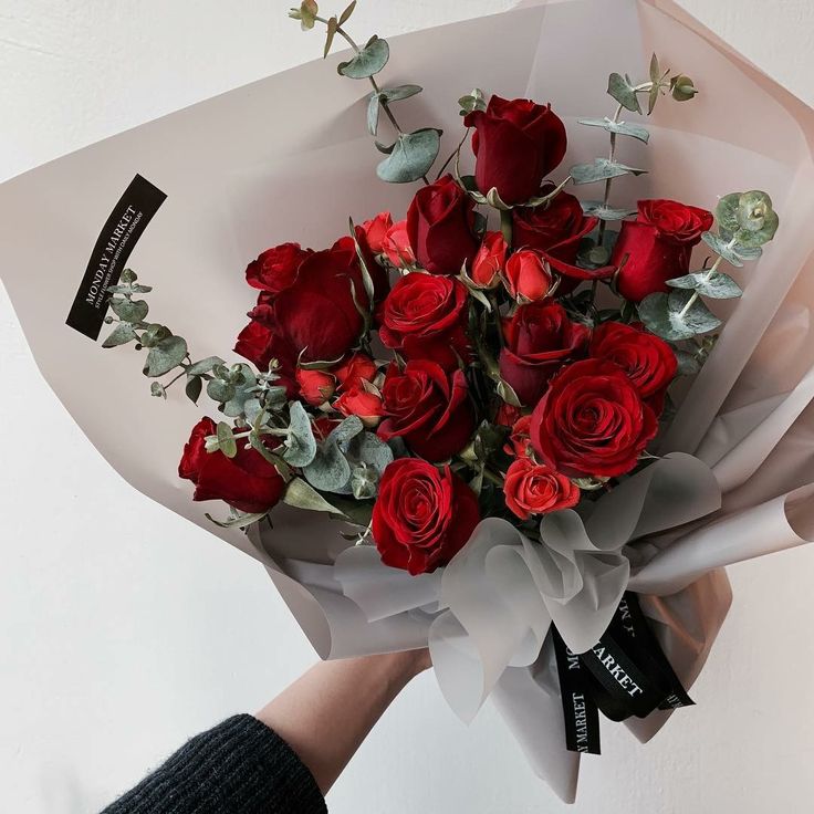 a person holding a bouquet of red roses