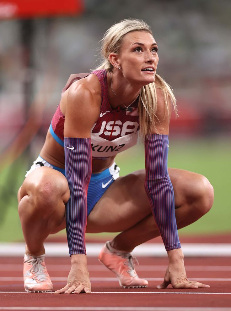 a woman kneeling down on top of a track