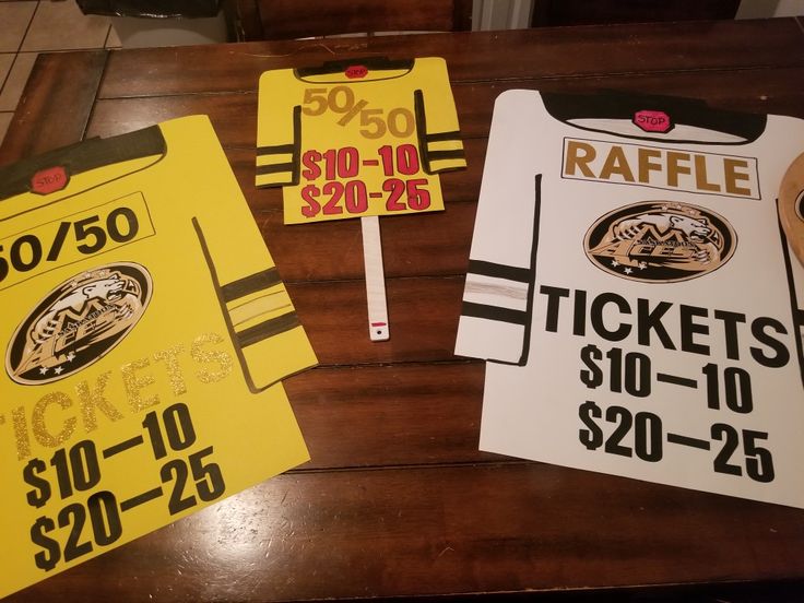 two tickets for raffle sitting on top of a wooden table next to each other