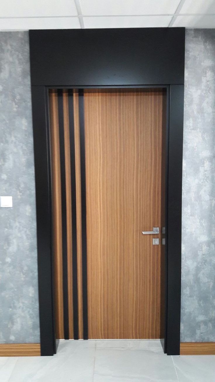 an empty room with a wooden door and tile flooring on the wall behind it