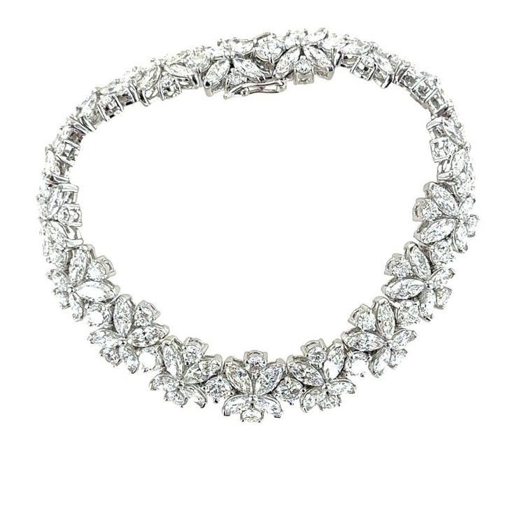 This platinum diamond estate bracelet is adorned with round brilliant and marquise diamonds to create a timeless and exquisite piece of jewelry. The combination of round brilliant and marquise diamonds features a captivating contrast of shapes and textures, creating a floral inspired design. The high quality diamonds weigh approximately 20 carat total weight and are graded G-H color and VS2-SI1 clarity. The bracelet measures 7.00 inches in length, .40 inches in width box clasp with 2 safety clasps. Stamped PT900. Weight: 42.8 grams. Luxury Marquise Diamond Bracelet With Brilliant Cut, Luxury Marquise Brilliant Cut Diamond Bracelet, Luxury Diamond Bracelet With Marquise Cut, Luxury Marquise Diamond Bracelet For Anniversary, Luxury Diamond Marquise Bracelets, Luxury Marquise Diamond Bracelets, Luxury Marquise Cut Bracelets For Anniversary, Luxury Marquise Diamond Cut Bracelets, Luxury Marquise Cut Diamond Bracelet For Formal Occasions