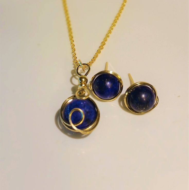 "Beautiful Natural Lapis Lazuli Necklace & Earrings Set In 14K Gold Filled Wire. This natural Lapis Lazuli has a fine, deep blue color with some Gold pyrite and calcite inclusions. The Lapis Lazuli Pendant has a 12 mm Round Stone Wire wrapped with 14K Gold Filled wire. The custom French Earring wires are 14K Gold Filled Wire wraping around 10 mm Lapis Lazuli Stones. Beautifully handmade and hammered in my Florida Studio. All 14k Gold Wire is Nickle free. These earrings come with soft silicon Navy Blue Jewelry, Lapis Earrings, Lapis Necklace, Lapis Lazuli Jewelry, Lapis Lazuli Earrings, Lapis Lazuli Pendant, Lapis Lazuli Necklace, Gold Filled Necklace, Lapis Lazuli Stone