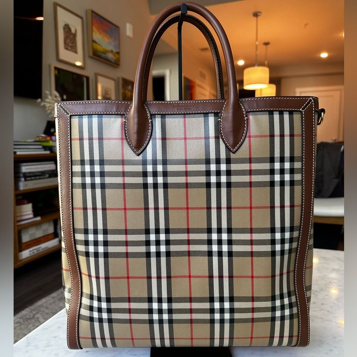 This Tote Is From The Riccardo Tisci Era Of Burberry, As Evidenced By The Logo Style. It Has Been Used Quite A Bit But Is Super Durable. The Check Pattern Is Coated Canvas And The Trim And Strap Are A Beautiful Brown Leather. There Are Some Scuffs On The Inside But No Major Stains. Approx Bag Dimensions: 14 In. X 14.5 In. X 4 In. Plenty Of Room For Average Size Computer, So Great For Work Or Travel. Includes Dust Bag And Shoulder Strap. Riccardo Tisci, Burberry Classic, Logo Style, Fashion Logo, Check Pattern, Womens Tote Bags, Brown Leather, Burberry, Dust Bag