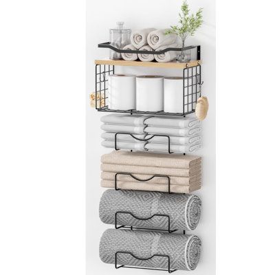 a wall mounted towel rack with towels and other bathroom items on top of each shelf