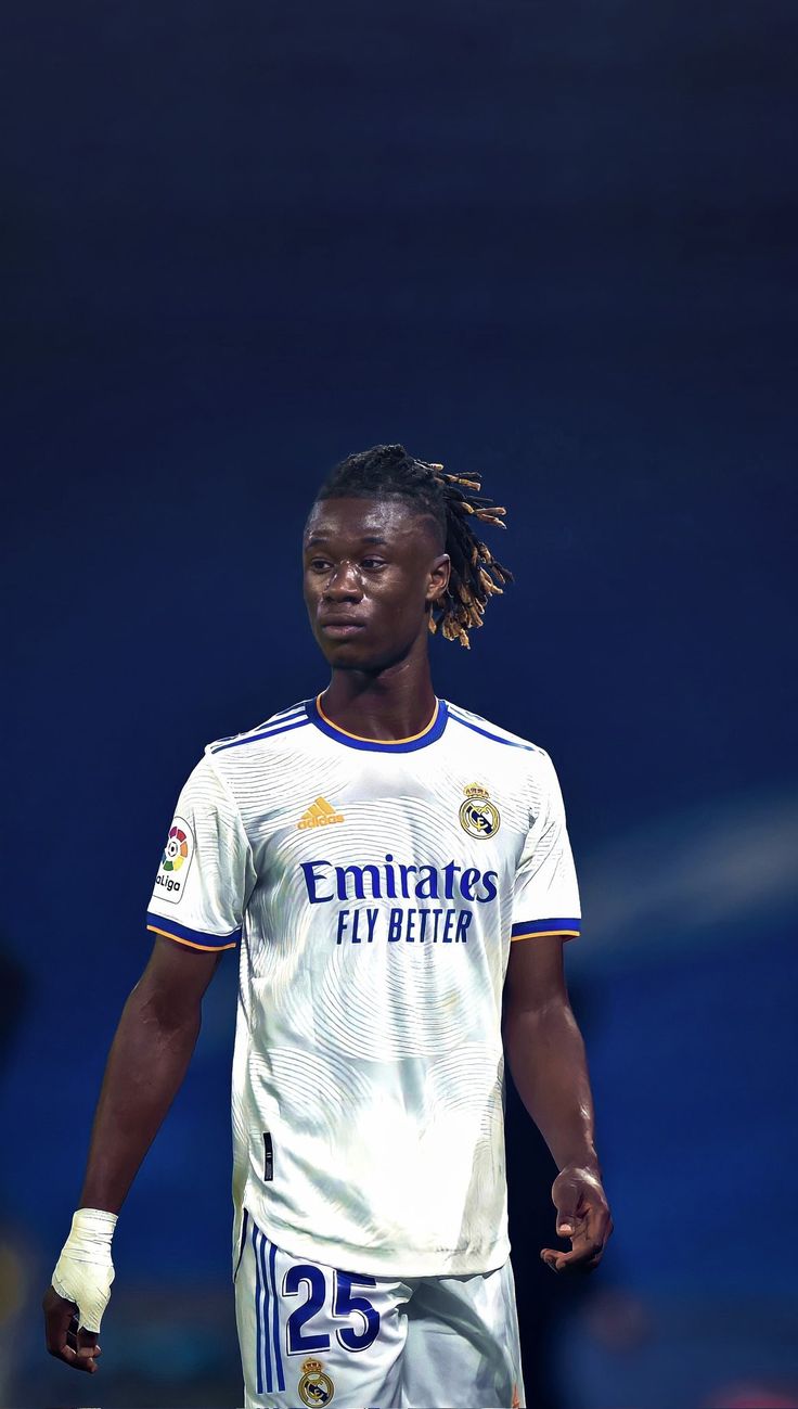 a soccer player with dreadlocks walking on the field