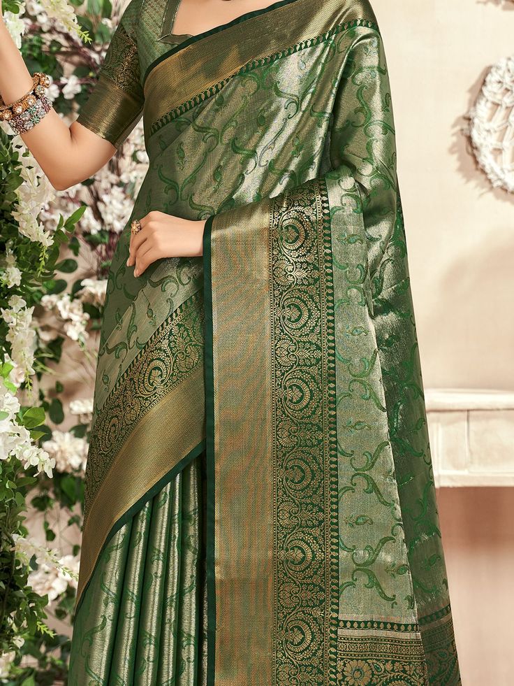 Celebrate your upcoming festivals, weddings, and occasions with the stunning "fascinating green zari weaving silk mehendi wear saree with blouse" from Ethnic Plus. This beautiful green saree is designed with intricate zari weaving work, adding a touch of elegance and sophistication to your ethnic look. The set includes a similar color silk blouse with zari weaving work, perfectly complementing the saree for a complete ensemble.
The saree is 5.50 meters in length, providing ample fabric to drape Elegant Green Pre-draped Saree For Transitional Season, Green Blouse Piece With Cutdana For Transitional Season, Transitional Green Blouse Piece With Cutdana, Festive Green Pre-draped Saree With Pallu, Green Bollywood Pre-draped Saree With Meenakari, Green Semi-stitched Pre-draped Saree With Meenakari, Festive Green Paithani Silk Pre-draped Saree, Green Chanderi Pre-draped Saree For Diwali, Festive Green Pre-draped Saree With Zari Weaving