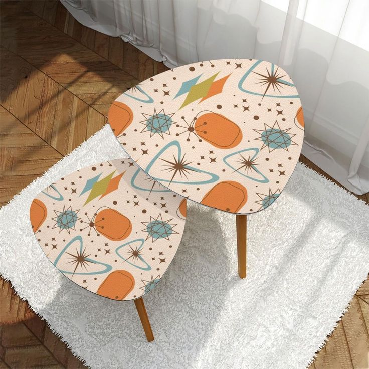 two tables with designs on them sitting on a rug