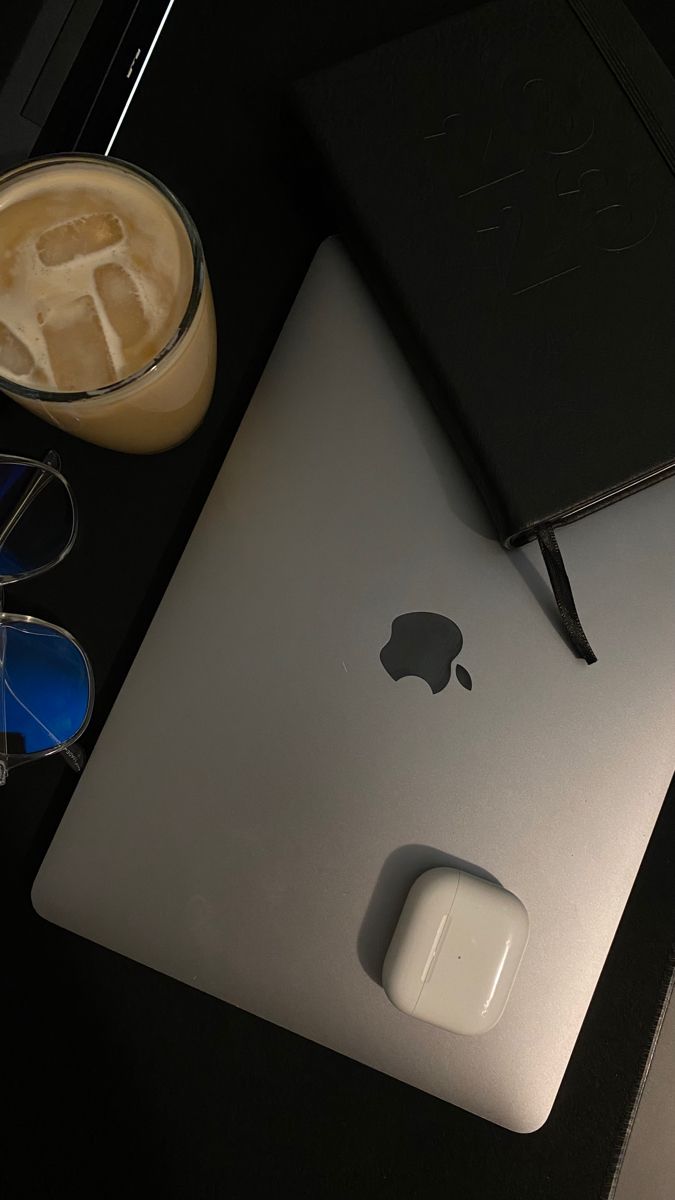 an apple computer sitting on top of a desk next to a cup of coffee and glasses