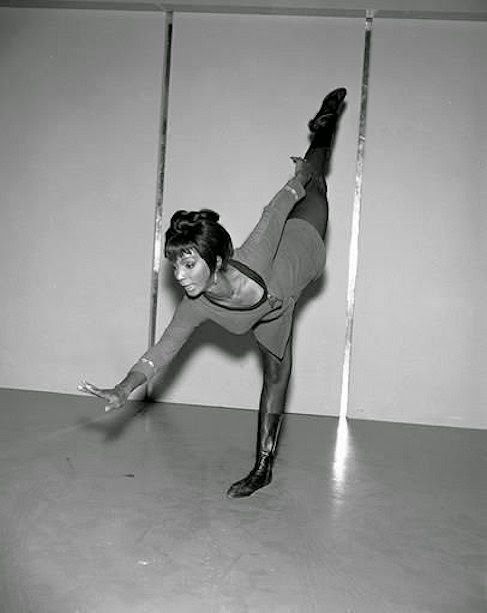 an old photo of a woman doing a handstand on one leg in the air