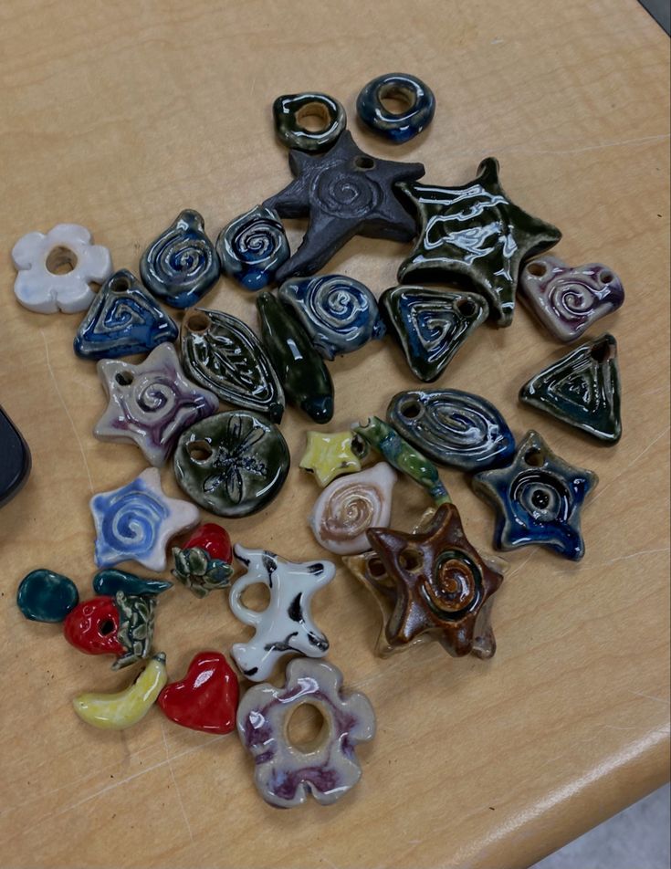 a table topped with lots of different types of glass buttons on top of a wooden table