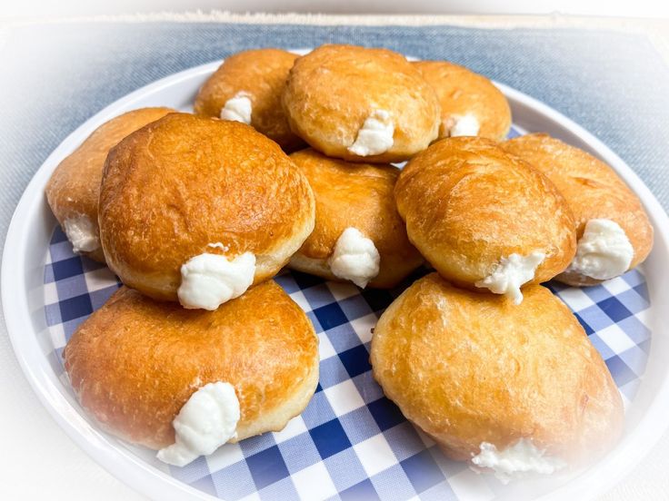 a white plate topped with donuts covered in cream next to a photo of a woman