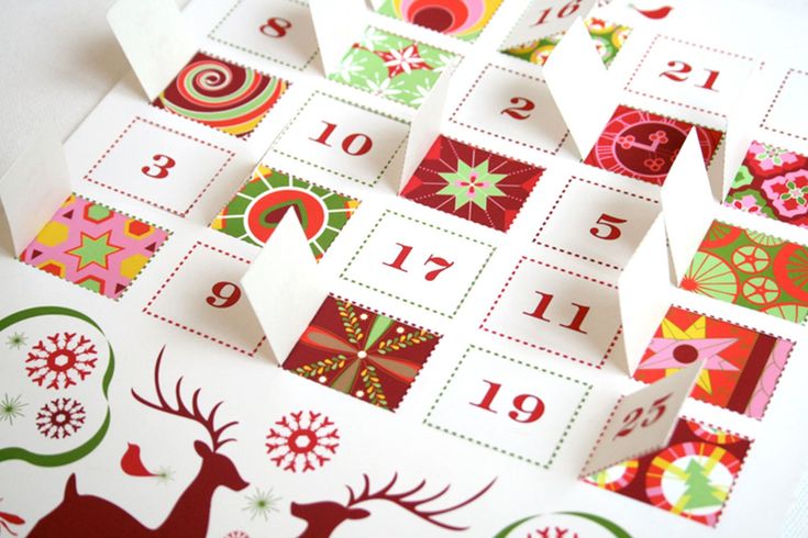 a christmas themed calendar with reindeers and snowflakes on the pages, cut out into squares