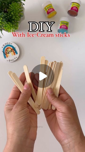 someone is making popsicle sticks with ice - cream sticks on the table next to them