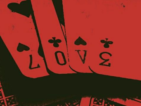 four playing cards with the word love written on them in black and red, sitting next to each other