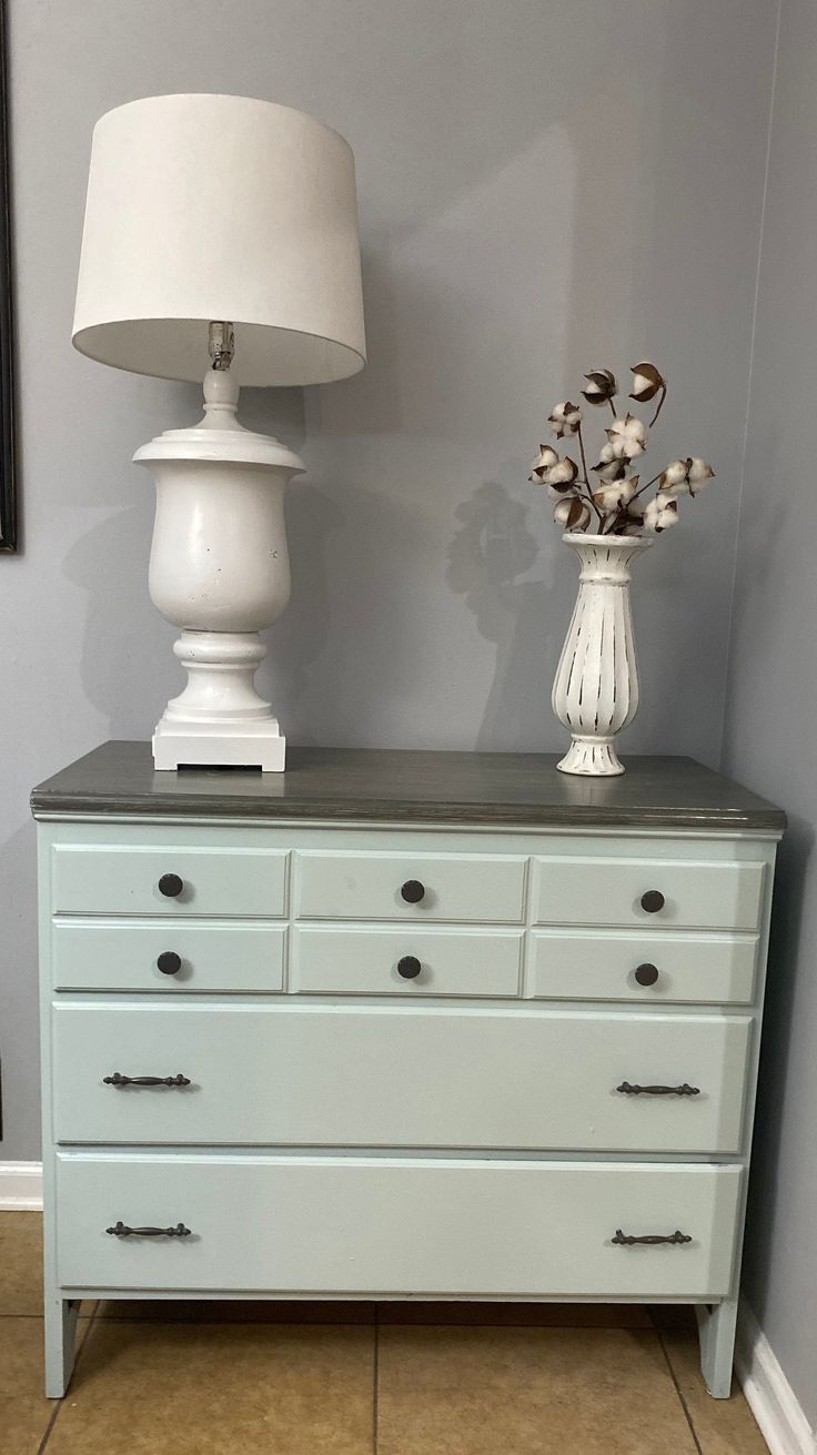 a white lamp sitting on top of a dresser