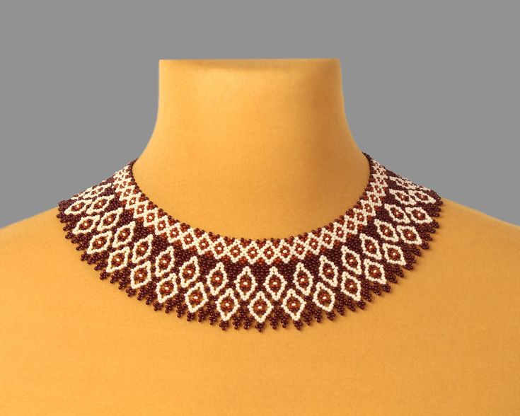 a brown and white beaded necklace on a mannequin neckline with beads