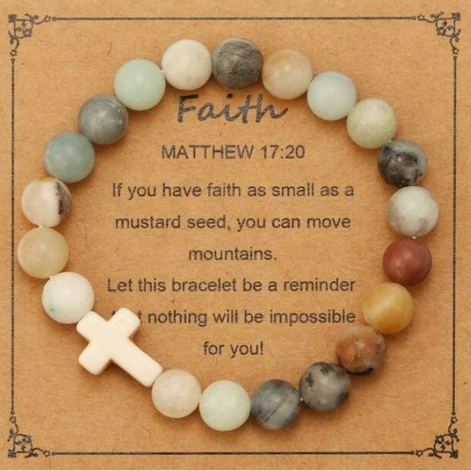 a bracelet with a cross on it and the words, faith written in white lettering